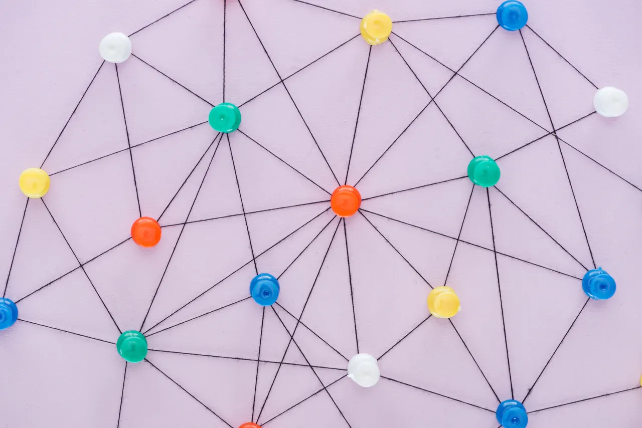 Colorful pins connected by threads, forming a web of relationships